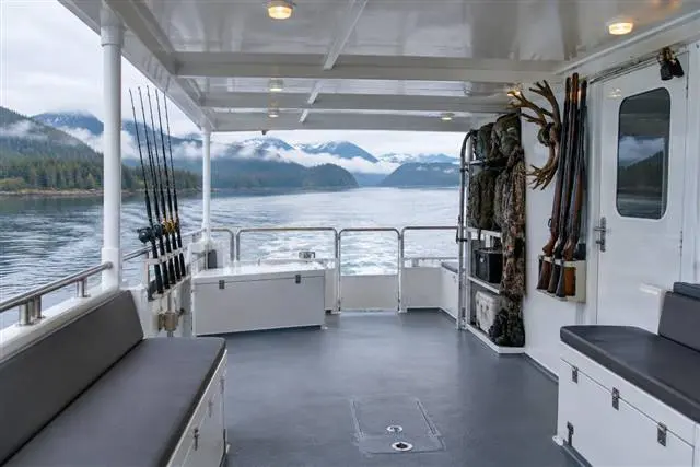 Covered deck areas | Alaska Coastal Hunts Covered aft deck of the charter vessel with seating and stored hunting gear